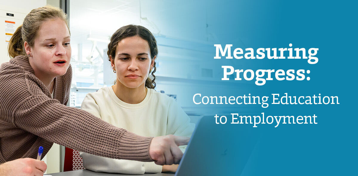 In white with a blue background, text says Measuring Progress: Connecting Education to Employment. There are two people wearing a brown and cream sweater, looking at a computer screen. The one person to the left is pointing at the screen.