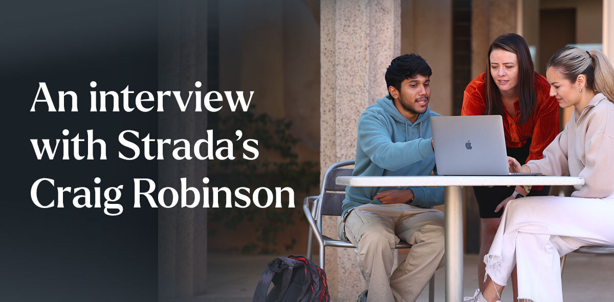 In white, text says An interview with Strada's Craig Robinson. There are three students sitting down looking over a laptop. 