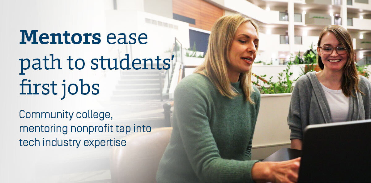 In dark blue, text says Mentors ease path to students' first jobs, community college mentoring nonprofit tap into tech industry expertise. There are two women interacting with each other and a computer screen. There is a hotel lobby with greenery in the background. 