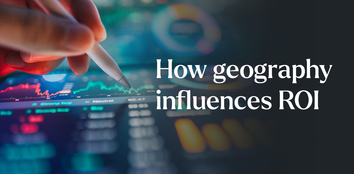 In white, text says how geography influences ROI. There is a hand with a stylus and dashboards on a screen to the left. 